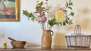 Um armário de madeira com quatro gavetas e um vaso com flores em cima.