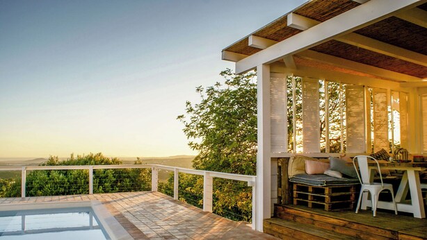 A poolside area with a view of the landscape, a wooden deck, and a seating area with a table and chairs. - Trendy villa with a remarkable view. (Santa Bárbara de Nexe)