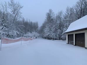 Um estacionamento coberto de neve, com um edifício à direita.