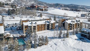 Een winters resort met meerdere gebouwen, een zwembad en een skilift.