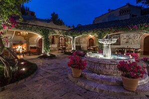 A courtyard with a fountain, seating areas, and a fireplace. - Villa Santa Monica (San Miguel de Allende)