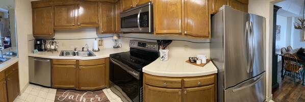 Enjoy cooking in this well-equipped kitchen with a microwave, oven, refrigerator, sink, and coffee maker.