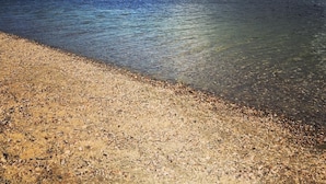 A beach with clear water and a pebbly shore. - Luxus Ferienwohnung für 6 P. mit Sauna & Holzofen - am Wasser und in Strandnähe (Geeste)