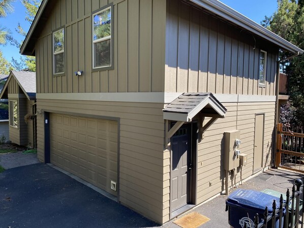 A two-story house with a garage, a front door, and a small porch. - Hillside Loft- Spacious Studio, 100+mbps Wifi, Gas Fireplace, AC, Balcony (Bend)
