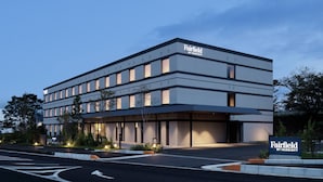 Un hôtel moderne, avec un toit plat, de nombreux étages et une enseigne indiquant qu’il appartient au groupe Marriott.