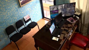 A room with a desk, two chairs, a computer, and a security camera. - Hotel Verano Azul (Santo Domingo)