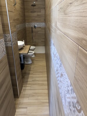 Een bad/douchecombinatie, een bubbelbad, een haardroger, een bidet