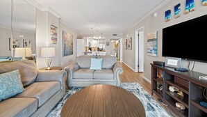 A modern living room with a sofa set, a coffee table, and a TV on a wooden stand.