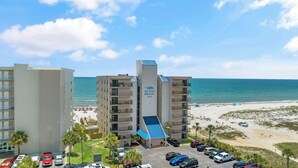 A multi-story hotel with a pool area and beach access, named "Ocean Breeze East."