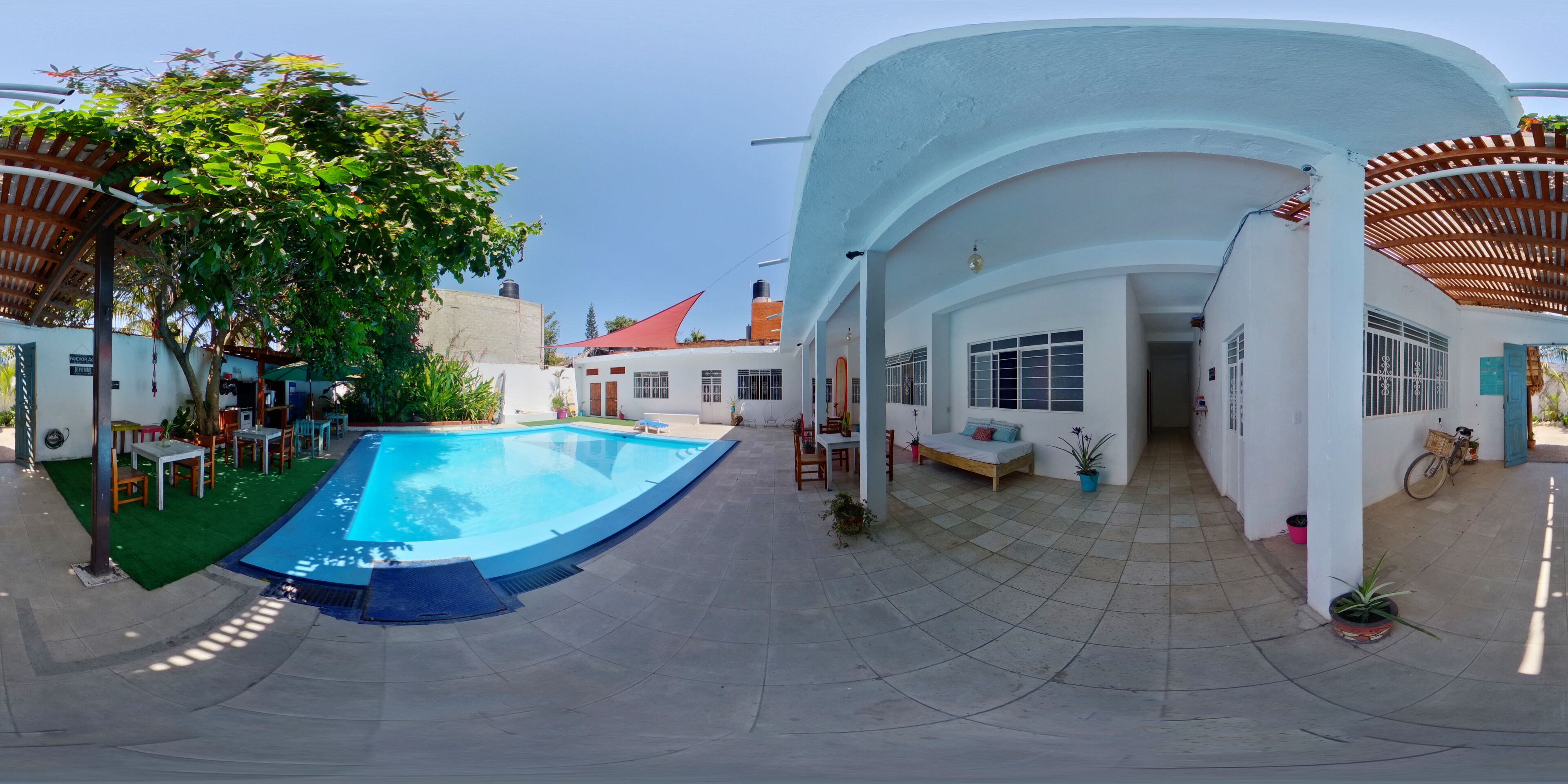 A swimming pool with a curved edge, surrounded by outdoor seating and potted plants.