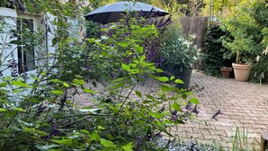 Un jardín con plantas en macetas y una valla de madera.