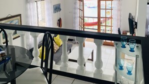 A spacious living area with a balcony, a dining table, and a seating arrangement. - Ocean View (St, George)
