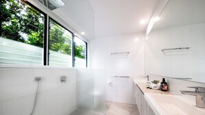 Une salle de bain moderne avec une douche à parois de verre, un meuble-lavabo et un grand miroir.