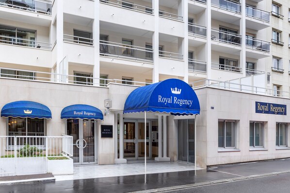 A hotel entrance with a blue canopy and a sign reading "Royal Regency."