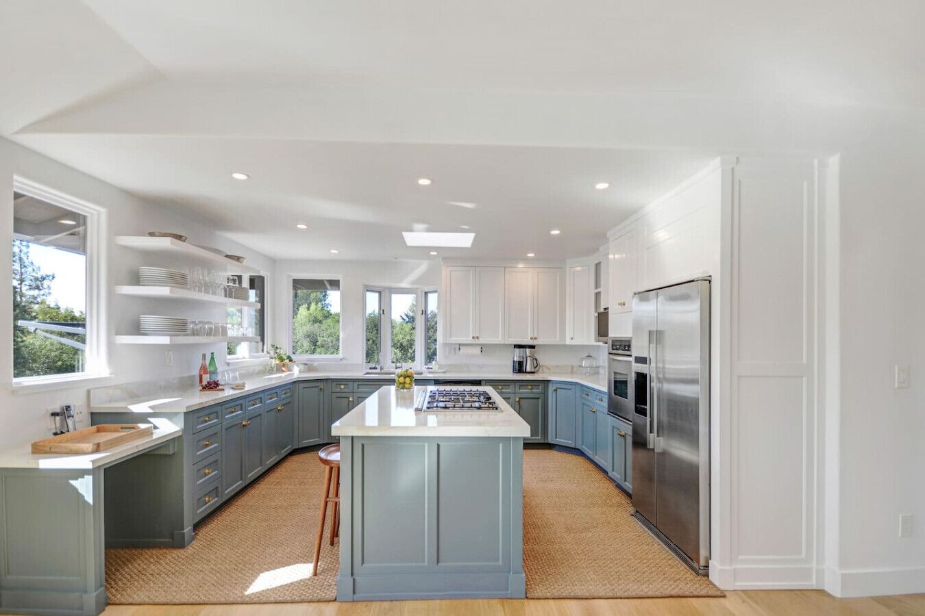Una cocina moderna con una isla central, electrodomésticos integrados y mucha luz natural.