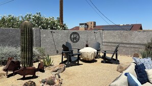 A patio area with outdoor seating, a cactus, and a decorative wall. - Beautiful Backyard Oasis Lake House (Lake Havasu City)