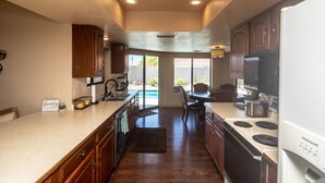 A modern kitchen with wooden cabinets, a built-in stove, and a large island. - Beautiful Backyard Oasis Lake House (Lake Havasu City)