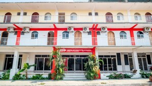 A multi-story hotel with a red and white facade, balconies with metal railings, and air conditioning units. - OYO Hotel Betsua Vista Hermosa, Huatulco (Santa María Huatulco)