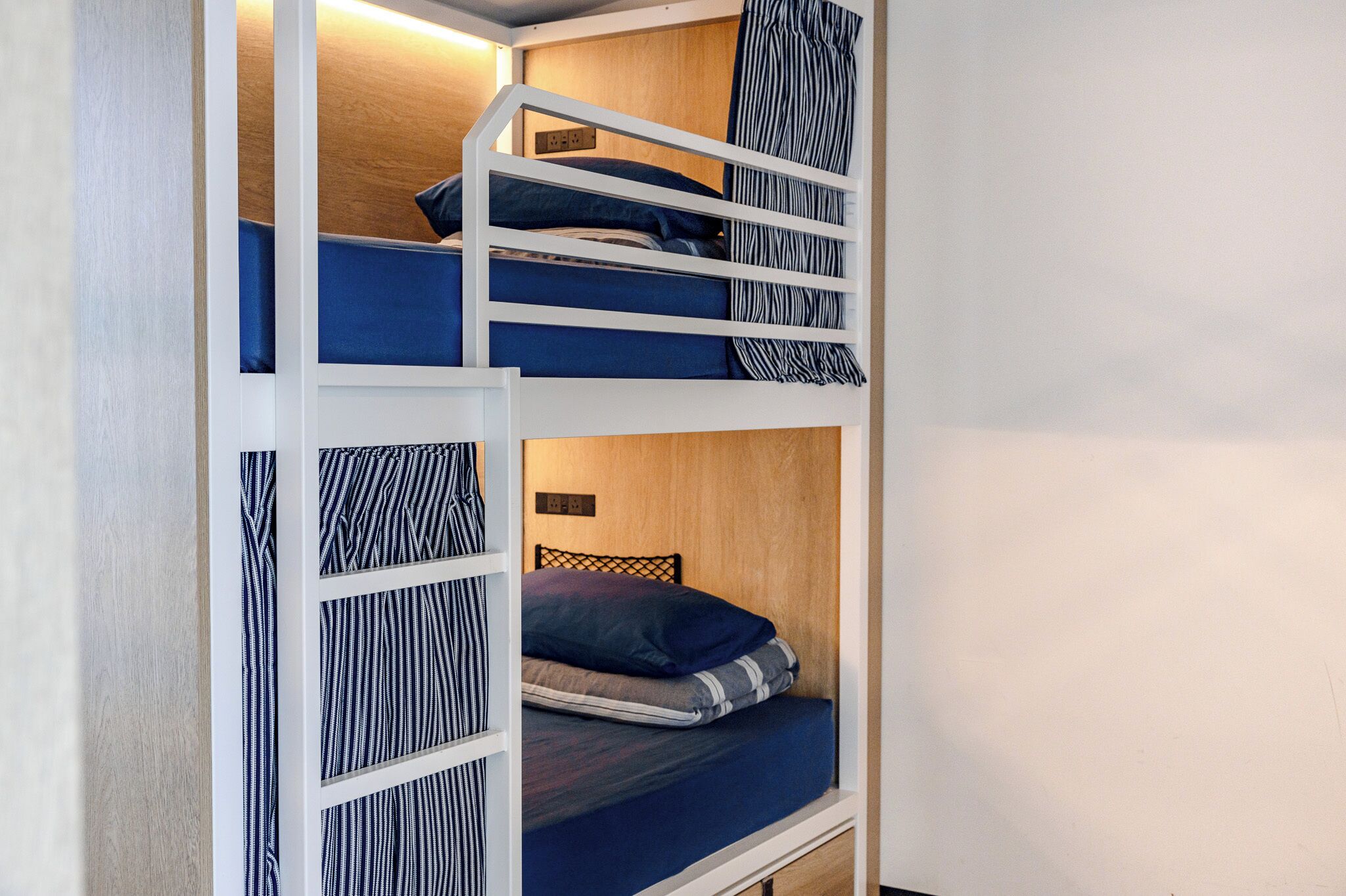 A bunk bed with a wooden headboard and a small shelf above it.