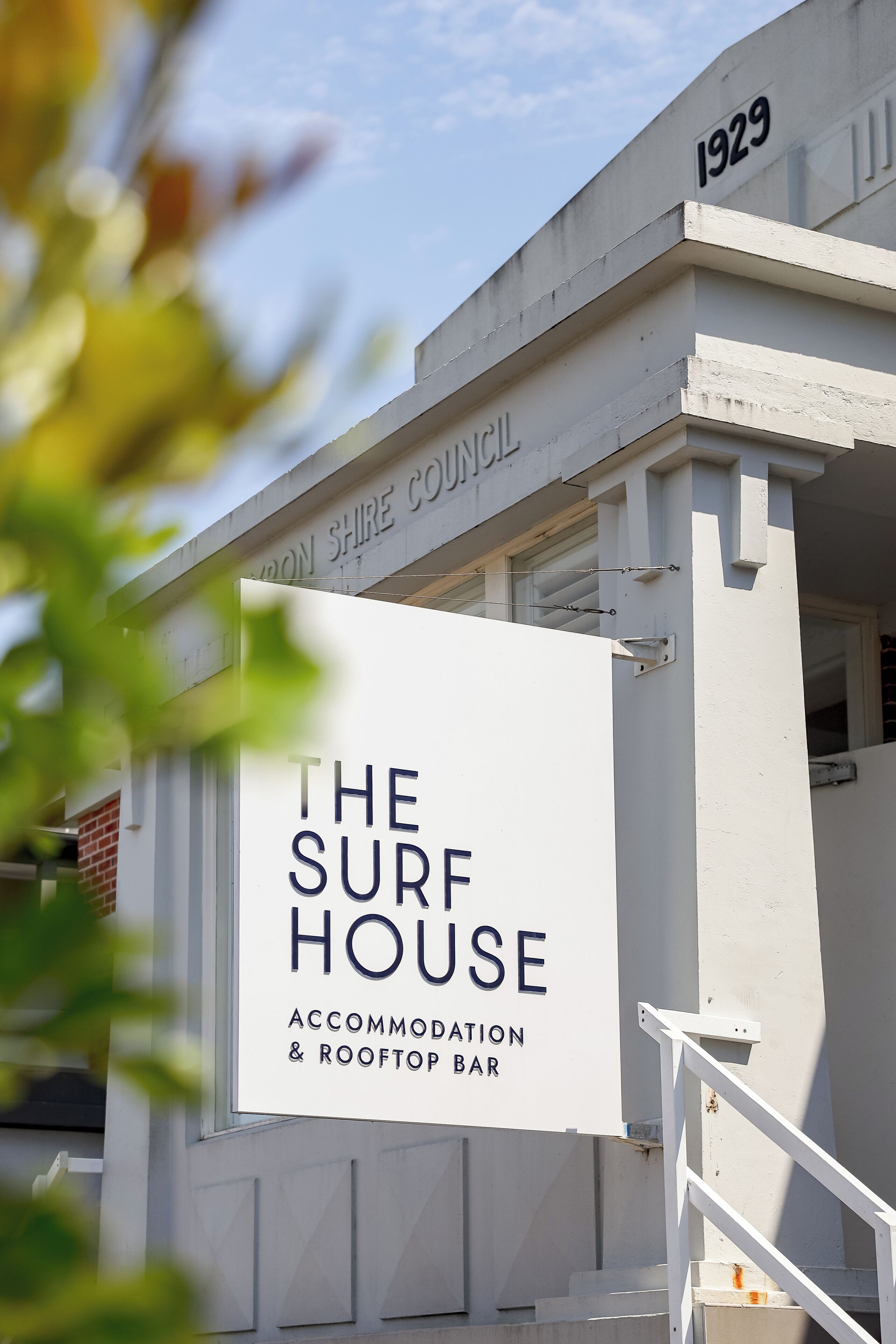 Un edificio con un letrero que dice 'The Surf House Accommodation & Rooftop Bar'.