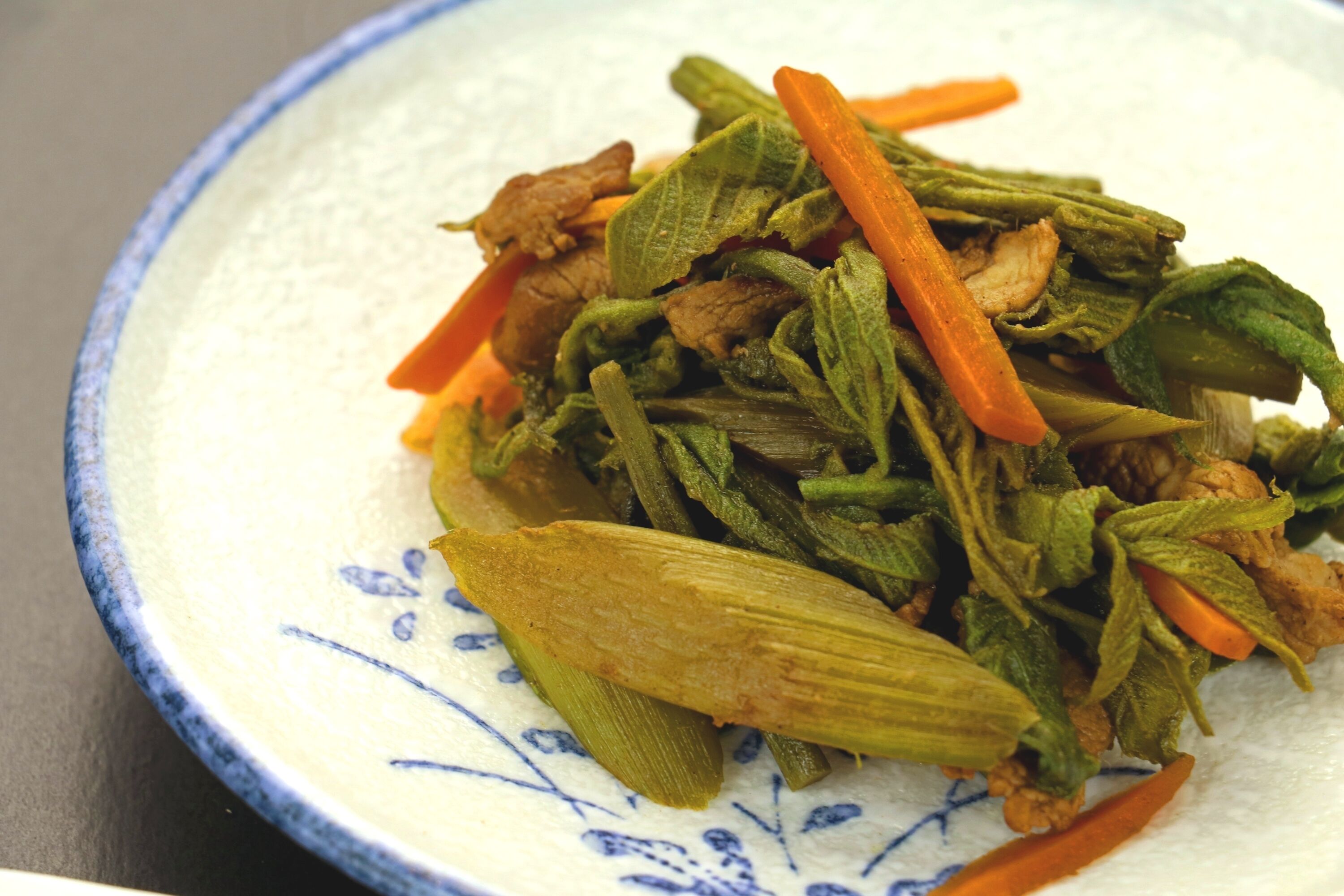 A plate of stir-fried vegetables including okra and carrots.