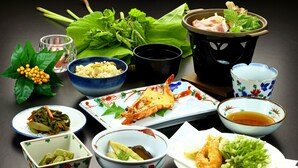A table with various dishes, including seafood, vegetables, and a bowl of soup. - Warabisou (Yuzawa)