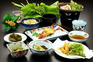 A table with various dishes, including seafood, vegetables, and a bowl of soup.