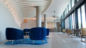 A modern lobby with blue seating, a reception desk, and large windows.