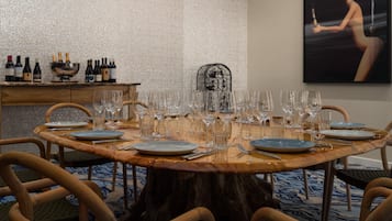Mesa redonda de jantar posta para refeição, com cadeiras ao redor.
