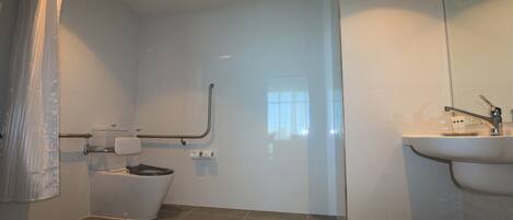 Un baño moderno con inodoro, ducha y lavamanos.