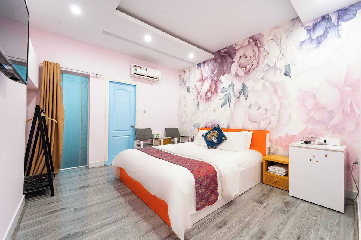 A bedroom with a bed, a wardrobe, a desk, and a chair.