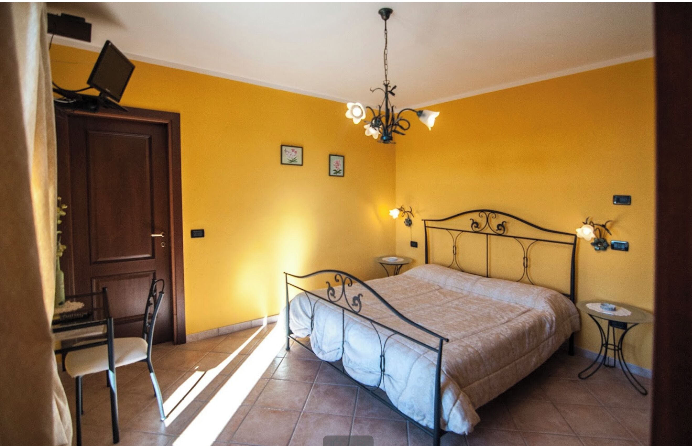 Une chambre à coucher avec un lit, une chaise, un bureau et une petite table.