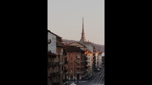 Vista de una calle con edificios, una imponente aguja de iglesia y cielo despejado.