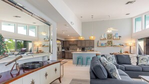 A modern kitchen with a central island, bar seating, and a large mirror.