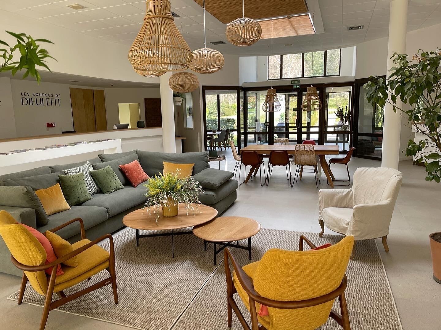 A modern living room with a sofa, chairs, a coffee table, and a dining area with a table and chairs.