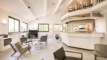 A spacious living area with a kitchen, dining area, and a balcony with a railing.