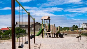 Ein Spielplatz mit Schaukeln, Rutschen und Klettergerüsten.