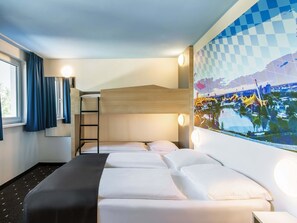 A hotel room with a bunk bed, a desk, a window with curtains, and a wall-mounted artwork. - B&B Hotel München City-Nord (Munich)
