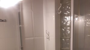 Un baño con lavamanos, espejo y cabina de ducha.