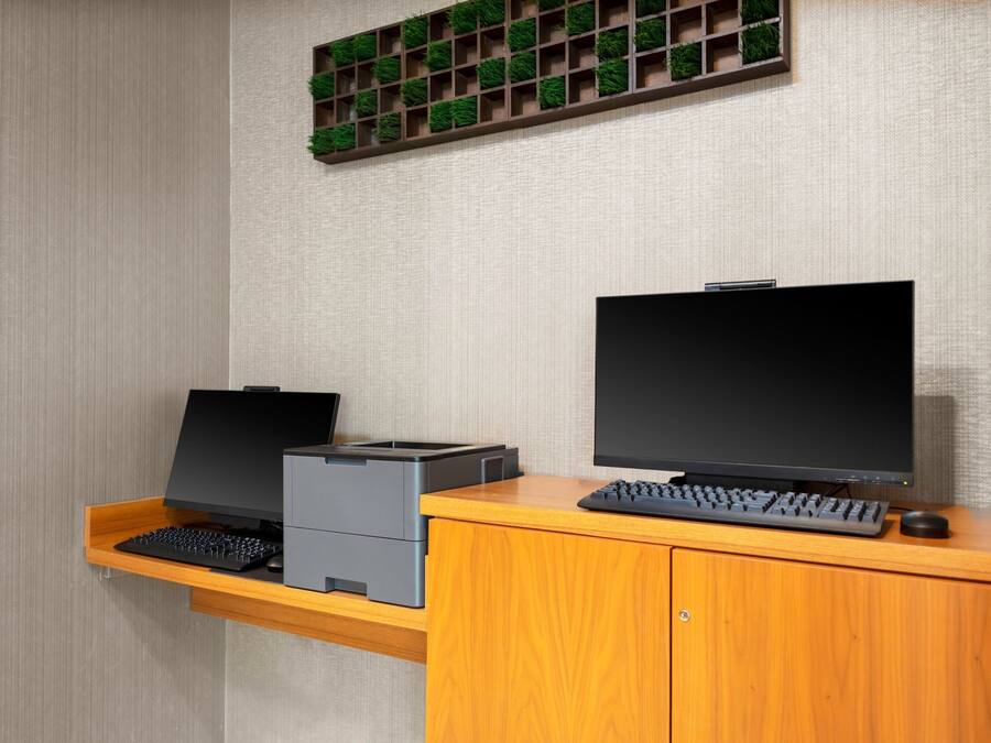 Ein Arbeitsplatz mit Schreibtisch, Computer, Tastatur und Drucker.