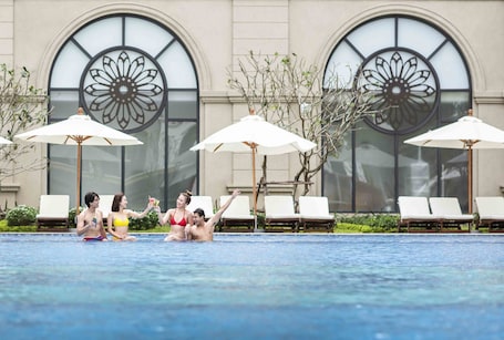 Una piscina al aire libre, sillones reclinables de piscina