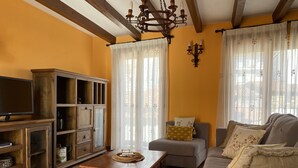 A living room with a wooden cabinet, a television, a sofa, and a coffee table. - RURAL HOUSE LA CABEZUELA (El Real de San Vicente)