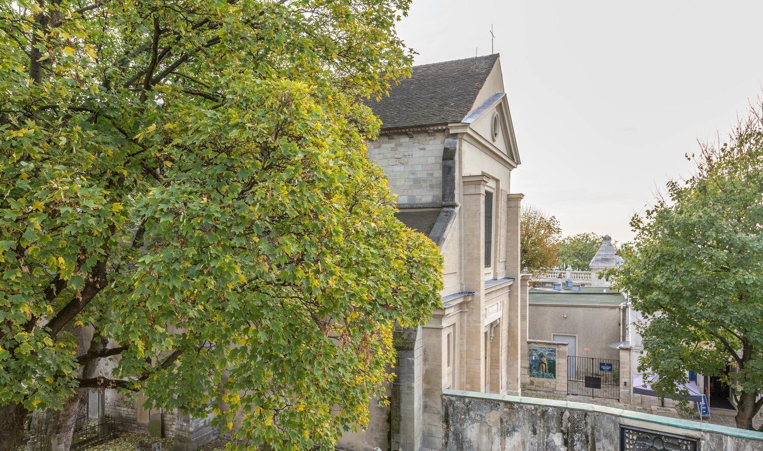 A historic building with a stone facade, a prominent tower, and a bridge in the foreground.