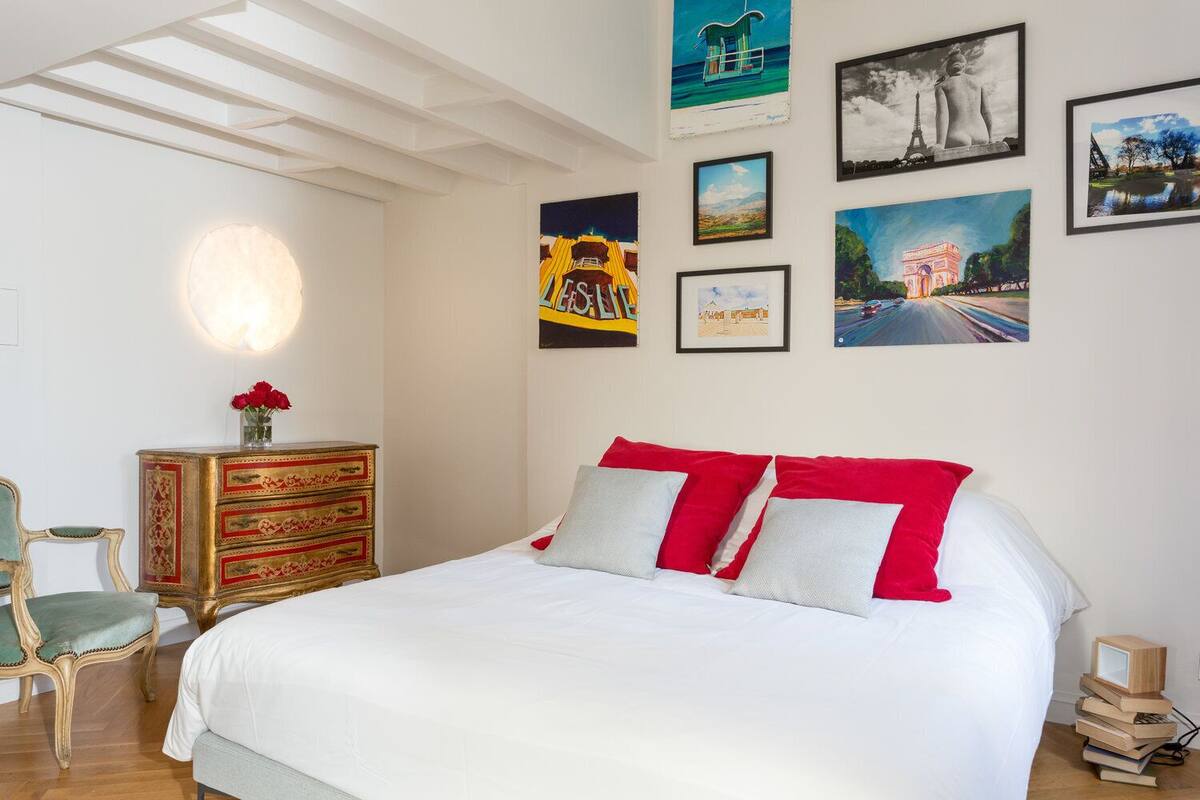Un dormitorio con una cama grande, un aparador y una silla.