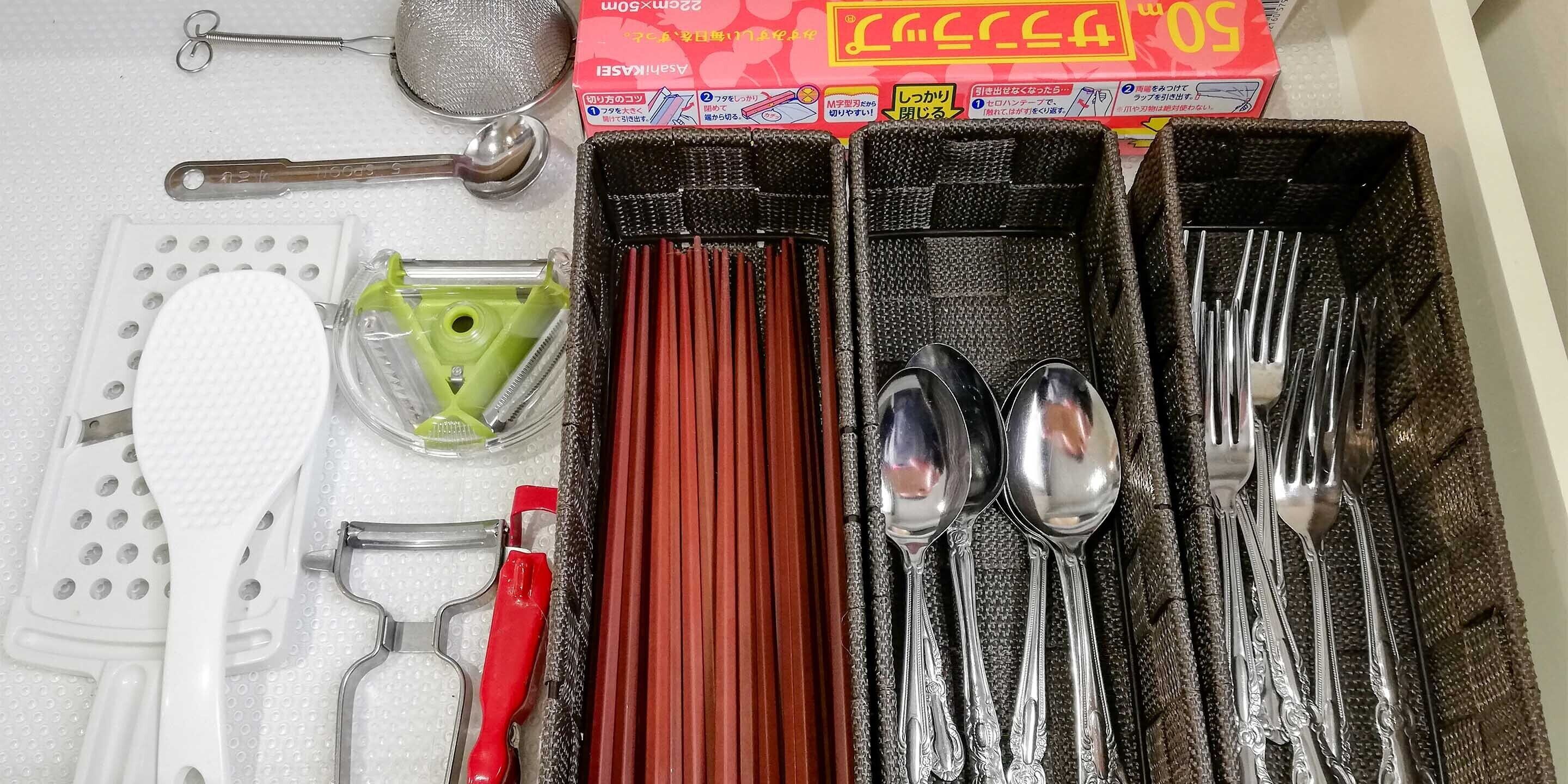 A kitchen with various utensils and appliances, including a grater, a strainer, and a set of knives.