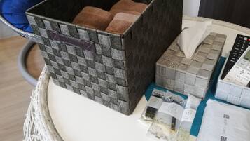 A basket containing various items including a woven basket, a tissue box, a remote control, and some packaged goods.