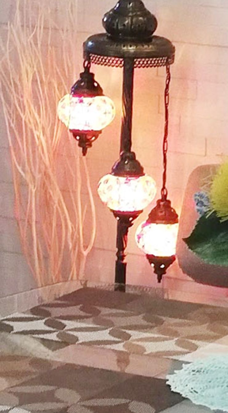 A hanging light fixture with three spherical lamps.