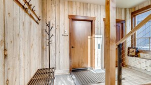 Un interno in legno con una porta di legno, un attaccapanni e una scala.