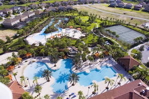 Oversigtsbillede af et resort med flere swimmingpools, palmer og en tennisbane.