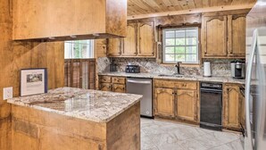 A kitchen with wooden cabinets, granite countertops, a built-in dishwasher, and a refrigerator. - Raven Rock - 31 Acres, HOT TUB, Stream, fire Pit, Private, High Speed Internet (Henderson County)